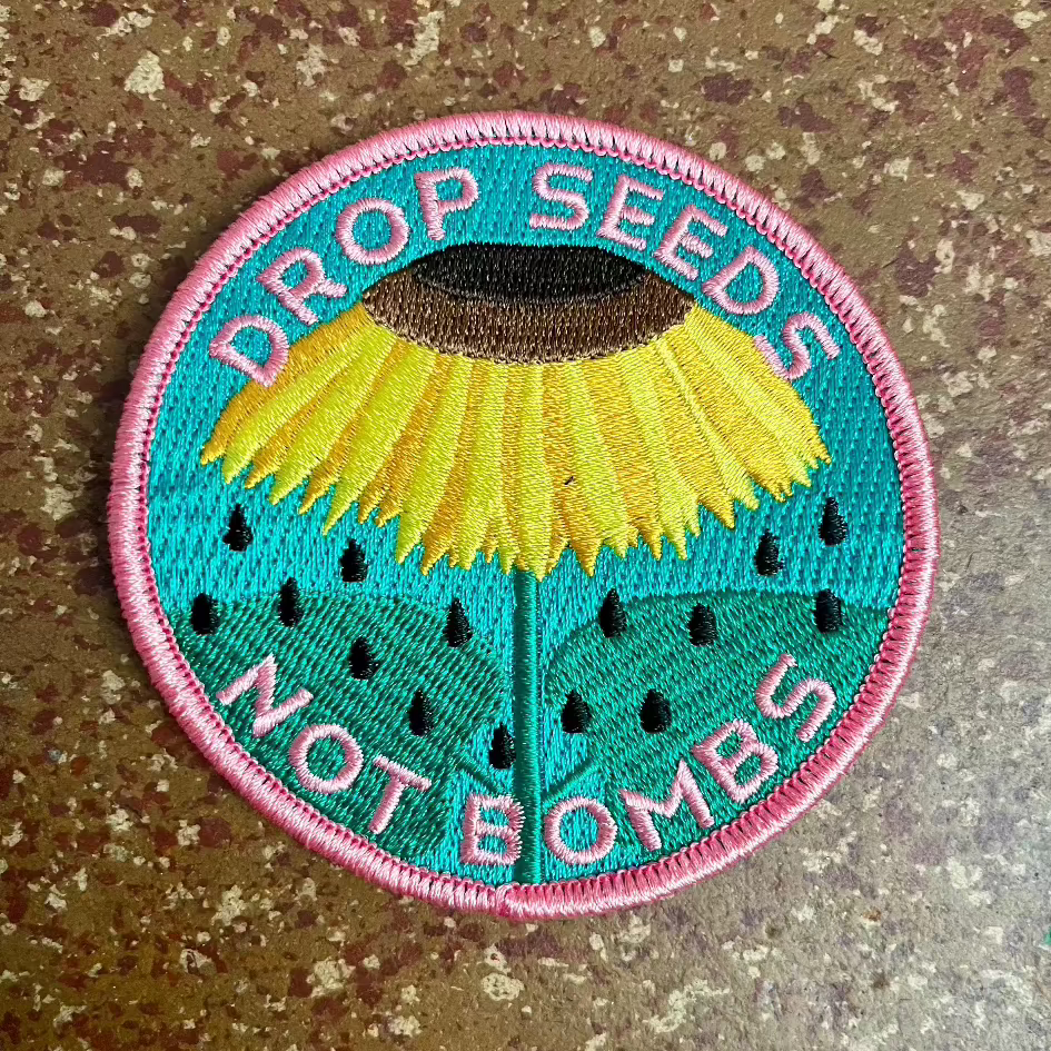 Haags Zaad - geborduurde patch DROP SEEDS NOT BOMBS Zonnebloem