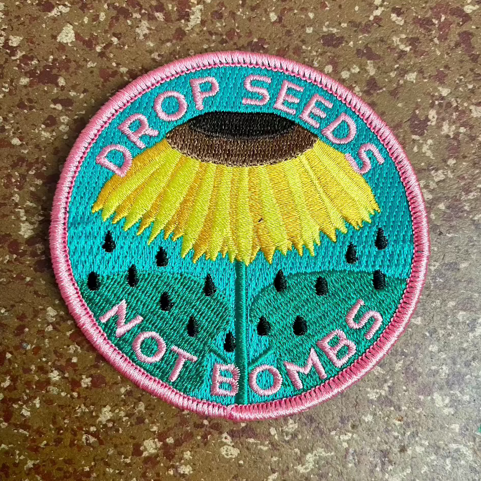 Haags Zaad - geborduurde patch DROP SEEDS  NOT BOMBS Zonnebloem